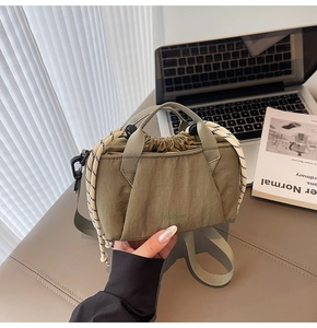 Detail of army green nylon bucket bag featuring drawstring closure and top handle