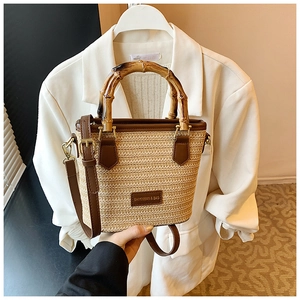 Vue détaillée du sac en paille bohème avec poignées en bambou naturel et bandoulière en cuir