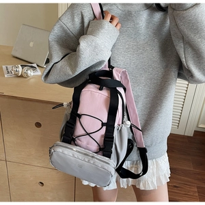 Detail view of pink and grey sports backpack with elastic cords and buckle strap
