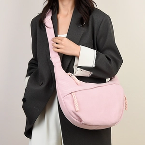 Detailed texture of pink corduroy material on a stylish half-moon crossbody bag