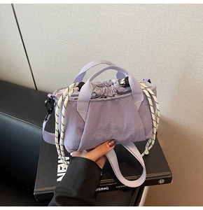 Detail of lavender drawstring bucket bag with pleated nylon fabric and woven side cords
