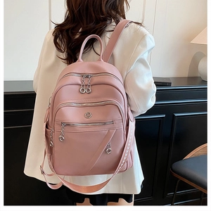Dettaglio zaino in morbida pelle rosa con tasche zip e spallacci con stampa grafica