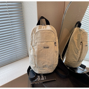 Detail of off-white waterproof nylon backpack with branded plaque and side pocket