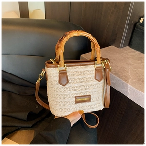 Détail du sac en paille tissé à la main avec poignées en bambou et finitions en cuir