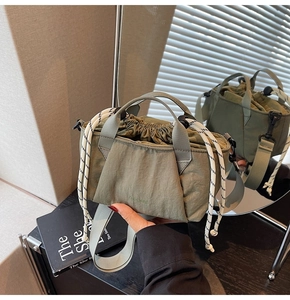 Detail of army green nylon bucket bag featuring a drawstring closure and logo print
