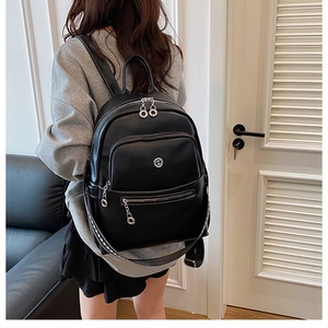Detail of black leather backpack with geometric pattern straps and silver hardware