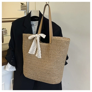Macro view of woven straw texture and delicate white lace bow on the summer tote bag