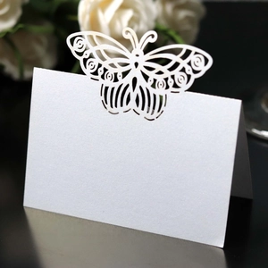 Macro view of laser-cut butterfly place card made of white pearl paper for weddings