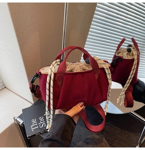 Detail view of burgundy bucket bag with drawstrings and embossed logo on thick fabric