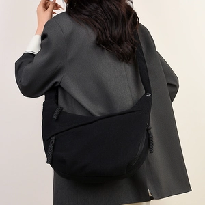 Detail of black corduroy hobo bag showing the rich ribbed texture and wide shoulder strap