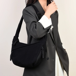 Detail view of a black corduroy crescent bag showing fabric texture and crossbody style