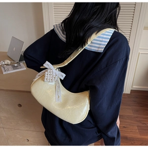 Hobo shoulder bag detail with ruffled leather, lace bow, and pearl heart pendant charm