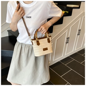 Détail du sac en paille tissée avec poignée en bambou et bandoulière en cuir marron