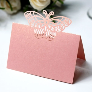 Macro detail of laser-cut pink butterfly place card on elegant pearlescent paper
