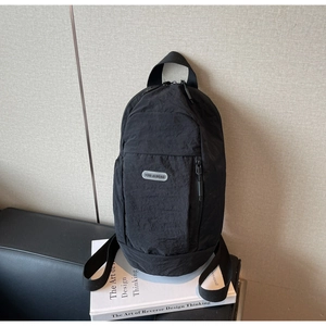 Detail of the black nylon chest bag with YOU JI BEAR logo and smooth zipper texture