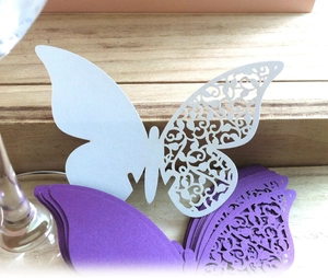 Detail of laser-cut butterfly place cards in white and purple pearlescent paper