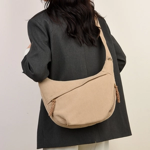 Detailed texture of beige corduroy half-moon crossbody bag with woven zipper pullers