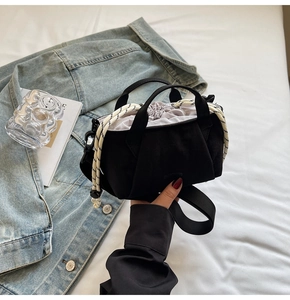 Detail of black fabric bucket bag with drawstring closure and woven rope handles