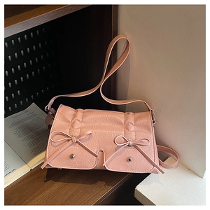 Pink vintage shoulder bag with textured pleats, double bows, and metallic silver studs