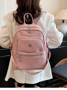 Pink pebbled leather backpack for women with side pockets and stylish metal badge