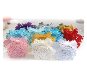 Assorted laser-cut flower pattern gift boxes with silk ribbons for wedding favors