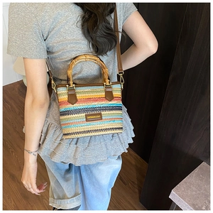 Détail du sac tressé coloré avec poignée en bambou et bandoulière en cuir marron de qualité