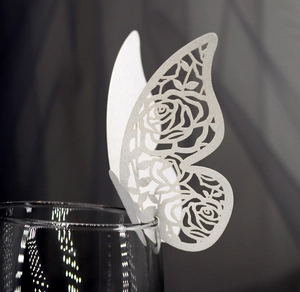 Gros plan d'une carte papillon blanche découpée au laser avec motif floral sur verre