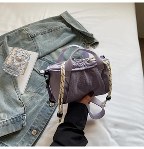 Detail of purple nylon bucket bag featuring drawstring closure and textured fabric
