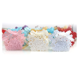 Detailed laser-cut floral candy boxes in multiple colors with matching silk ribbons