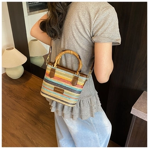 Détail du sac bandoulière bohème en paille avec anses en bambou et rayures colorées