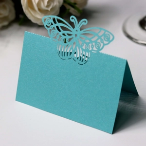 Detailed laser-cut butterfly place card in deep teal with a subtle pearlescent finish