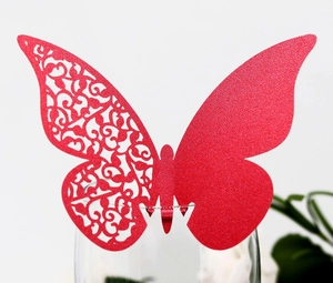Detail of red glitter butterfly wine glass place cards with intricate hollowed patterns