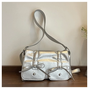 Detail of silver metallic handbag featuring bow-tie pockets and unique crinkle texture