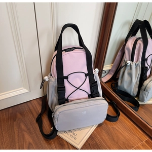 Detail of pink and grey backpack with detachable pouch, elastic cords and buckles