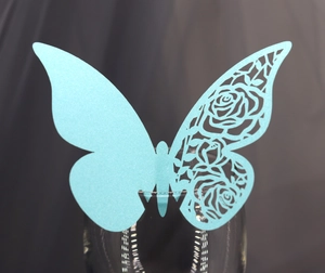 Gros plan d'une carte papillon bleu ciel découpée au laser avec motifs de roses