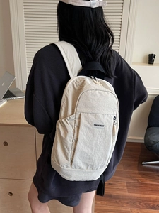 Stylish cream nylon backpack for women shown on a model in a cozy home office setting