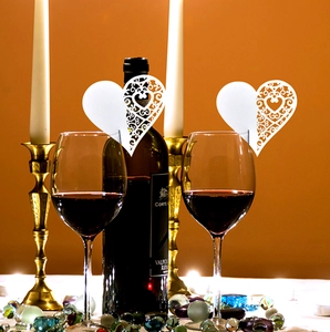Laser cut heart shaped wine glass place cards in white with hollow floral pattern design