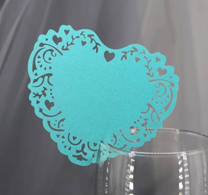 Light blue heart-shaped laser-cut paper cards for wedding guest seating and glass decor