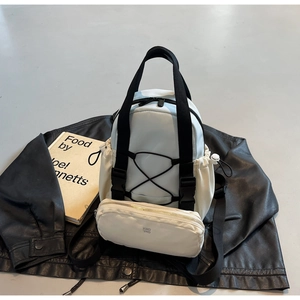 Flat lay of light blue utility backpack with KMD 2ND pouch and black drawstring detail