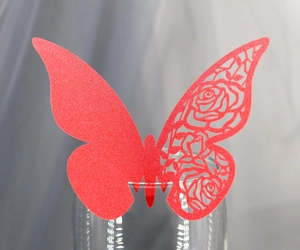 Gros plan sur carte papillon rouge découpée au laser avec motif de rose ajouré élégant