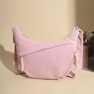 Detail of light pink corduroy crescent bag showing vertical texture and zipper puller