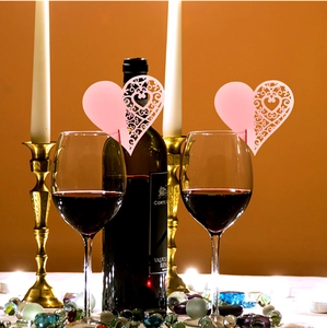 Pink heart-shaped laser cut place cards for wine glasses on a romantic wedding table