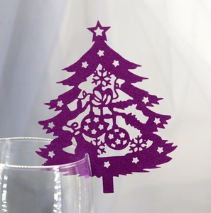 Purple laser-cut Christmas tree wine glass cards with intricate snowflake patterns