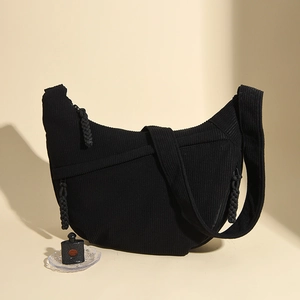 Detailed close-up of black corduroy hobo bag featuring woven rope zipper pulls