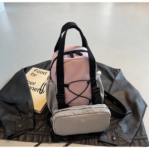 Detailed view of a pink and grey nylon backpack with a matching pouch on a black jacket