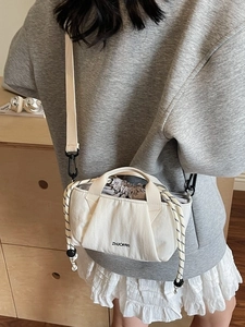 White nylon mini bucket bag with drawstring closure and patterned shoulder strap for women