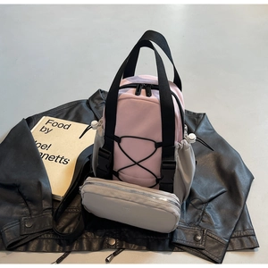 Detail of pink and grey nylon backpack with elastic cords and detachable coin purse