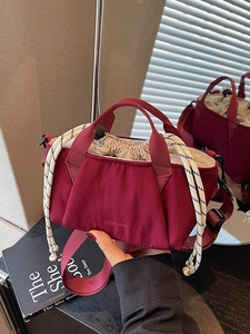 Chic burgundy nylon bucket bag with cream drawstring closure and adjustable strap