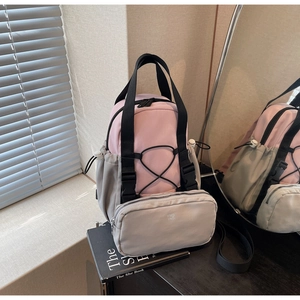Detail view of pink and grey mini backpack with drawstring and matching zipper pouch