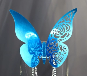 Papillon décoratif bleu découpé au laser avec motifs de roses sur bord d'un verre
